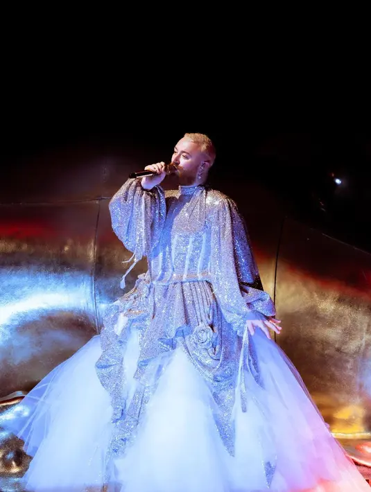 Di foto ini, Sam Smith kembali tampil dengan sebuah gaun. Gaun pilihannya kali ini berwarna abu-abu, yang juga panjangnya menjuntai hingga ke lantai, dengan lengan balon yang cantik dan bahan berkilauan. [Foto: Instagram/samsmith]
