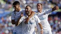 Penyerang Real Madrid, Karim Benzema (tengah) melakukan selebrasi bersama Marco Asensio (kiri) dan Lucas Vazquez, usai mencetak gol ke gawang Getafe, pada laga lanjutan La Liga 2017-2018, di Coliseum Alfonso Perez, Sabtu (14/10/2017).  (AFP/Oscar Del Pozo