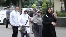 Istri Ustaz Alhabsyi, Putri Aisah Aminah didampingi keluarganya memasuki Gedung Ditreskrimum Polda Metro Jaya, (31/5). Putri menjalani pemeriksaan atas tuduhan perampasan disertai kekerasan terhadap asisten rumah tangganya. (Liputan6.com/Herman Zakharia)