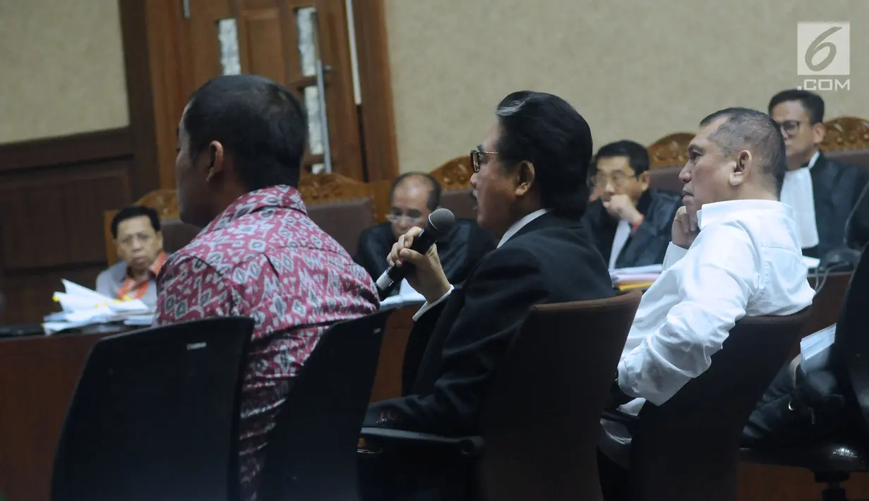 Pengacara Hotma Sitompul (tengah) menjawab pertanyaan majelis hakim pada sidang lanjutan dugaan korupsi proyek e-KTP dengan terdakwa, Setya Novanto di Pengadilan Tipikor, Jakarta, Kamis (1/2). (Liputan6.com/Helmi Fithriansyah)