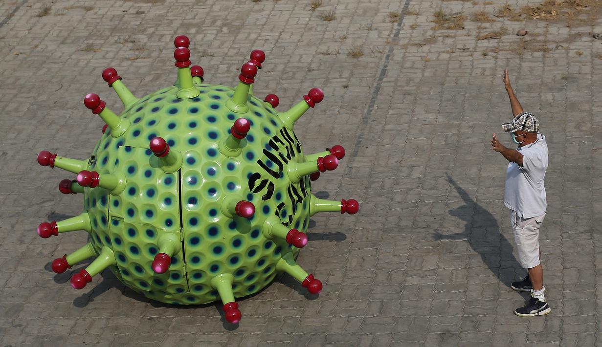 Desainer mobil India K. Sudhakar Yadav berdiri di samping mobil bertema Coronavirus di museum yang ia buat sebagai bagian dari kampanye kesadaran yang bertujuan mencegah penyebaran virus di Hyderabad, India, Selasa (7/4/2020). (AP Photo/Mahesh Kumar A.)
