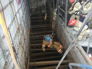 Petugas penyelamat dengan menggunakan tali turun ke lokasi robohnya konstruksi kereta bawah tanah di kota Namyangju, dekat Seoul, Korsel, Rabu (1/6). Empat pekerja tewas dan 10 orang lainnya luka-luka dalam insiden ini. (NAMYANGJU FIRE STATION/AFP)