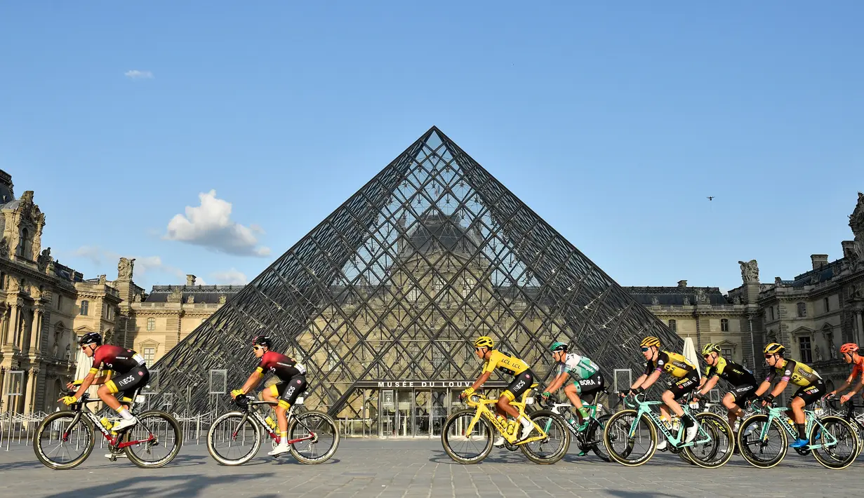 Pebalap Kolombia Egan Bernal (tengah) melewati museum piramida Louvre saat mengikuti Tour de France 2019, Paris, Prancis, Minggu (28/7/2019 ). Tour de France 2019 dimulai dari Rambouillet dan berakhir di Paris. (Julien de Rosa/Pool Photo via AP)