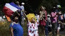 Aksi suporter memegang bendera Prancis saat menonton balapan  Tour de France pada etape ke-16 dengan jarak 165 km dari Le Puy-en-Velay dan Romans-sur-Isere, (18/7/2017).  (AFP/Jeff Pachoud)