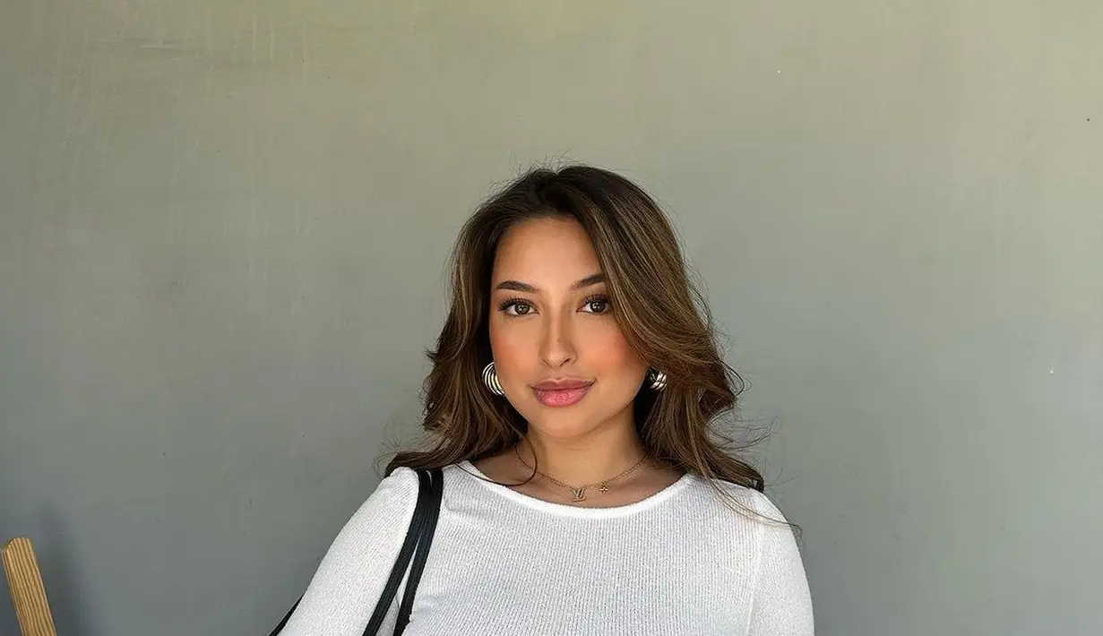 Jennifer Coppen terlihat menawan pamerkan baby bump menjelang kelahiran bayinya. Ia tampil simpel dengan t-shirt dress putih lengan panjang. [Foto: Instagram/jennifercoppenreal20]