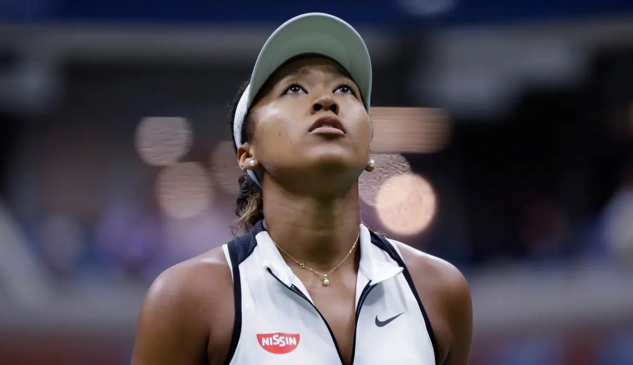 Petenis Jepang, Naomi Osaka menatap papan skor melawan petenis Swiss, Belinda Bencic pada babak keempat turnamen AS Terbuka 2019 di Arthur Ashe Stadium, Senin (2/9/2019). Naomi Osaka tersingkir AS Terbuka setelah menyerah dalam tempo 1 jam 27 menit dengan skor 5-7 dan 4-6. (AP/Frank Franklin II)