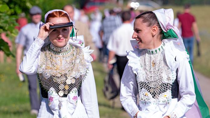Sejumlah wanita berpakaian tradisional Sorbs saat akan mengikuti kebaktian dalam ritual Whit Monday di Rosenthal, Jerman, Senin (10/6/2019). Whit Monday menjadi hari libur nasional di Jerman dan banyak negara lain. (AP Photo/Jens Meyer)
