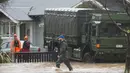 Petugas mengevakuasi pemilik rumah di Christchurch, Selandia Baru, Sabtu, (22/7). Banjir yang meluas telah menyebabkan kekacauan terutama di daerah pesisir Pulau Selatan. (AP Photo / Mark Baker)