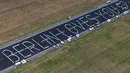 Pemandangan udara dari helikopter menunjukkan meja-meja yang ditata dalam bentuk pesan bertuliskan 'Berlin Loves You' (Berlin Mencintaimu) saat 3.000 warga menghadiri acara Berlin Freedom Dinner di landasan pacu bekas bandara Tegel di Berlin pada 7 Agustus 2021. (Christophe Gateau / DPA / AFP)