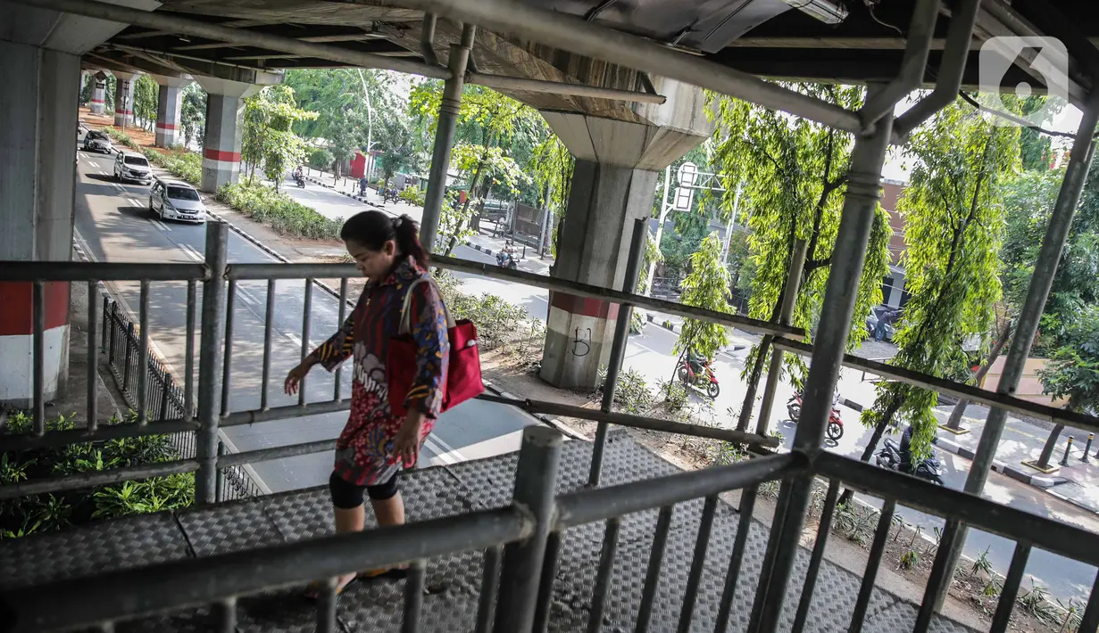 Pejalan kaki melintas di jembatan penyeberangan orang (JPO) halte transjakarta Bea Cukai di Jalan Ahmad Yani, Jatinegara, Jakarta, Kamis (5/12/2019). Sementara ini JPO hanya dipasang besi seadanya sebagai pengaman untuk para pengguna yang melintasi jembatan tersebut. (Liputan6.com/Faizal Fanani)
