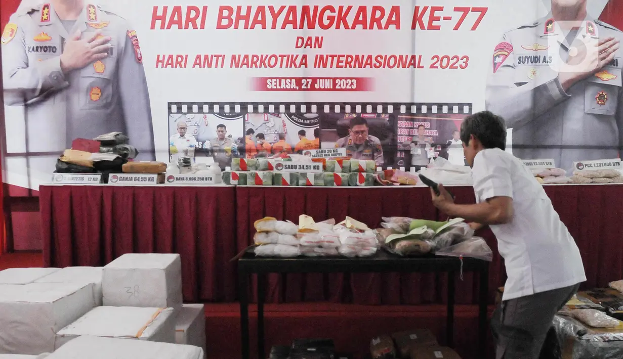 Polisi menata barang bukti saat pemusnahan barang bukti puluhan kilogram narkoba berbagai jenis di halaman Ditnarkoba Polda Metro Jaya, Jakarta, Selasa (27/6). (merdeka.com/Imam Buhori)
