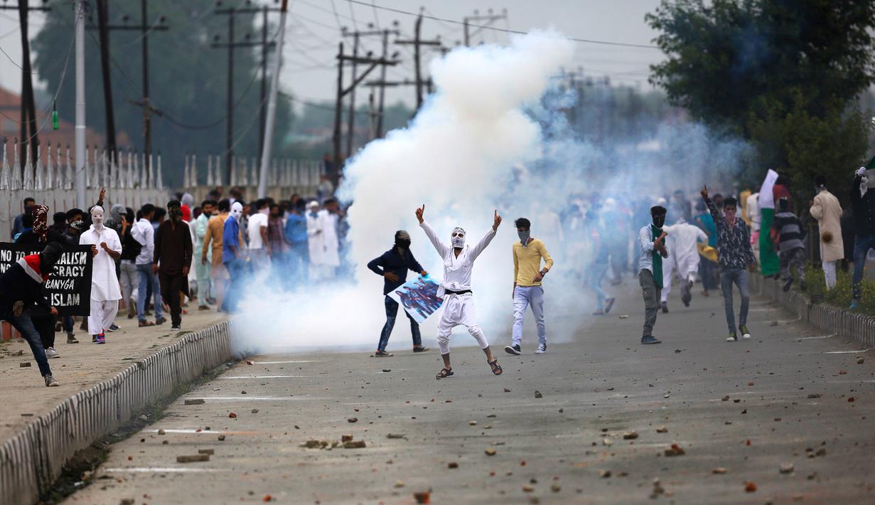 Sejumlah warga turun ke jalan melakukan aksi protes usai salat Idul Fitri di Srinagar, India (26/6). Bentrokan antara pengujuk rasa dan pihak keamanan setempat terjadi usai salat Idul Fitri yang digelar di Srinagar. (AP Photo / Mukhtar Khan)