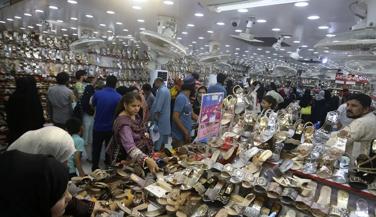 <p>Orang-orang mengunjungi pasar untuk membeli sepatu dan barang-barang lainnya untuk persiapan perayaan Idul Fitri mendatang, di Karachi, Pakistan, Jumat, 29 April 2022. Idul Fitri menandai berakhirnya bulan suci Ramadhan.</p>