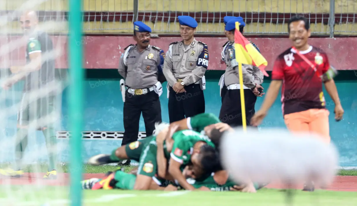 Polisi tersenyum saat melihat para pemain Bhayangkara Surabaya United merayakan gol ke gawang Persib Bandung pada lanjutan Torabika SC 2016 di Stadion Gelora Delta Sidoarjo, Sabtu (11/6/2016). (Bola.com/Nicklas Hanoatubun)