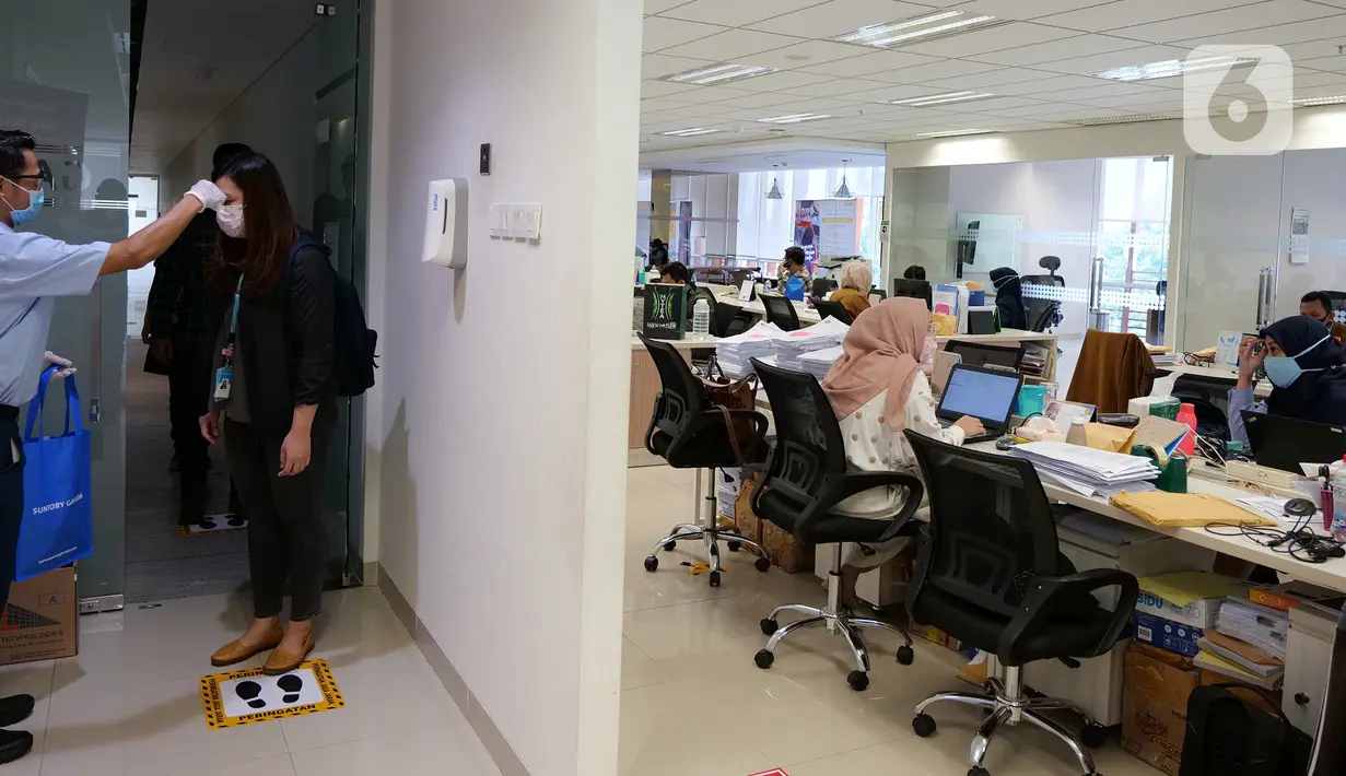 Petugas mengecek suhu tubuh karyawan sebelum memasuki ruang kerja di Suntory Garuda, Jakarta, Senin (8/8/2020). Perusahaan tersebut menerapkan protokol kesehatan saat hari pertama kerja di masa PSBB transisi yang diterapkan oleh Pemprov DKI Jakarta. (Liputan6.com/Herman Zakharia)