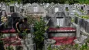 Warga keturunan Tionghoa membersihkan makam keluarga saat Festival Cheng Beng di Pemakaman Tionghoa di Japakeh, Banda Aceh, Aceh, Minggu (26/3/2023). (CHAIDEER MAHYUDDIN/AFP)