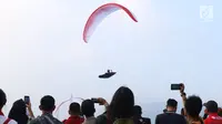 Salah satu atlet paralayang nomor cross country unjuk kebolehan saat latihan di kawasan Puncak, Cianjur, Jawa Barat, Kamis (26/7). Selain meninjau kesiapan venue, Menpora juga melihat latihan atlet paralayang Indonesia. (Liputan6.com/Helmi Fithriansyah)