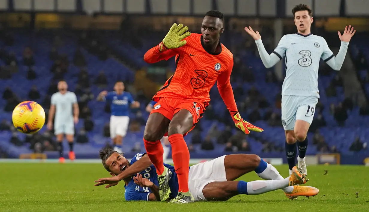 Striker Everton, Dominic Calvert-Lewin (bawah), dijatuhkan kiper Chelsea, Edouard Mendy, yang menghasilkan hukuman penalti dalam laga lanjutan Liga Inggris 2020/21 pekan ke-12 di Goodison Park Stadium, Sabtu (12/12/2020). Everton menang 1-0 atas Chelsea. (AFP/Jon Super/Pool)