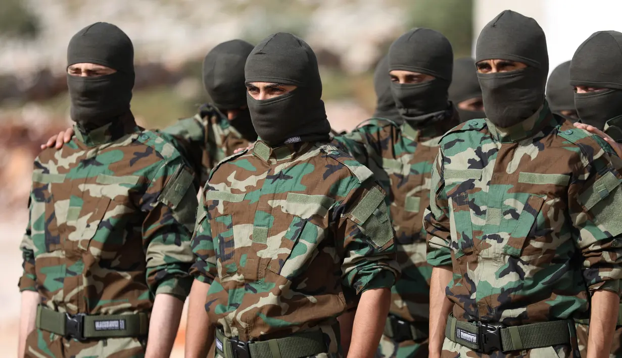 Pejuang dari Jaysh al-Izza (the Army of Glory) membentuk barisan saat melakukan latihan di kota Idlib, Suriah (9/4). Pejuang Jaish Al-Izzah merupakan bagian dari pasukan tentara pembebasan Suriah. (AFP/Omar Haj Kadour)