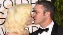 Penyanyi Lady Gaga dan sang tunangan, Taylor Kinney saling berciuman dengan mesra saat ditengah-tengah sesi foto ajang penghargaan film tahunan, Golden Globes 2016 di Beverly Hilton Hotel, California, Minggu (10/1). (Jason Merritt/Getty Images/AFP)