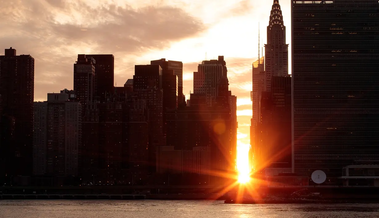 Pemandangan Manhattanhenge di New York, AS, Senin (11/7). Manhattanhenge adalah sebutan untuk sunset sempurna di New York di mana matahari berada tepat di antara 2 gedung yang terbelah dengan jalan. (Drew Angerer / Getty Images / AFP)