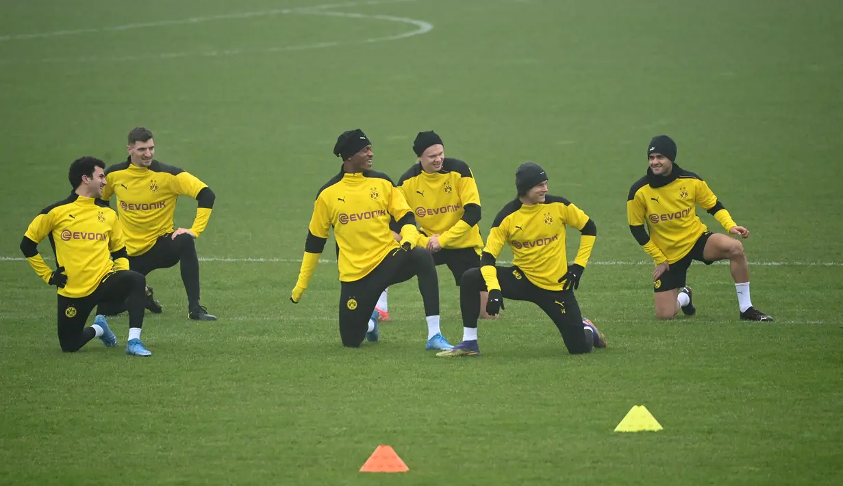 Para pemain Borrusia Dortmund melakukan pemanasan selama sesi latihan di tempat latihan tim di Dortmund, Jerman barat (9/3/2021). Dortmund sebelumnya berhasil mengalahkan Sevilla dengan skor 3-2 di leg pertama. (AFP/Ina Fassbender)