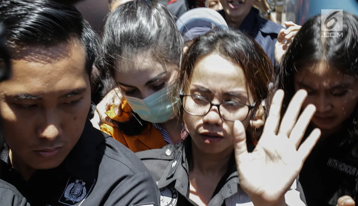 Artis dan tersangka kasus narkoba Jennfer Dunn dikawal ketat penyidik Polda Metro setibanya di Kejaksaan Negeri Jakarta Selatan, Kamis (15/3). Jennifer yang mengenakan baju tahanan berwarna oranye langsung dibawa menuju sel. (Liputan6.com/Faizal Fanani)