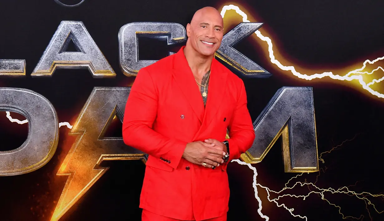 Aktor AS Dwayne Johnson tiba untuk pemutaran perdana film 'Black Adam' di Time Square, New York City, Amerika Serikat, 12 Oktober 2022. Aktor berusia 50 yang menjadi karakter utama film tersebut memerankan tubuh kekarnya dalam balutan jas merah dengan celana panjang yang senada. (AFP/ANGELA WEISS)