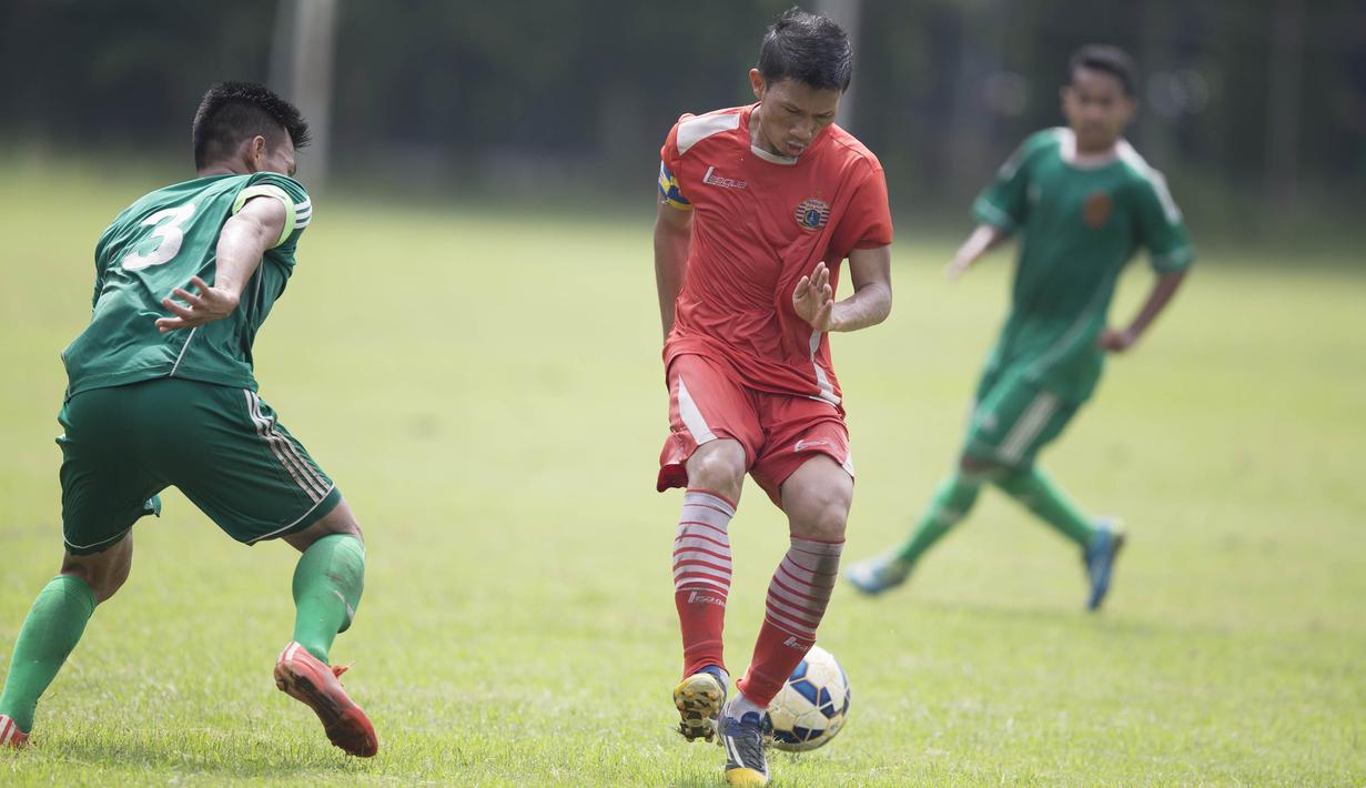 Bek sayap Persija Jakarta, Ismed Sofyan, menahan laju pemain PS AD pada laga uji coba di Lapangan Villa 2000, Tangerang, Jumat (4/3/2016). (Bola.com/Vitalis Yogi Trisna)