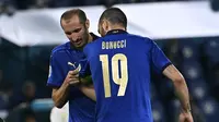 Bek Italia, Giorgio Chiellini memberikan ban kapten kepada rekannya, Leonardo Bonucci dalam laga Grup A Euro 2020 di Olimpico Stadium, Roma, Kamis (17/6/2021) dini hari WIB. (Foto: AP/Pool/Andreas Solaro)