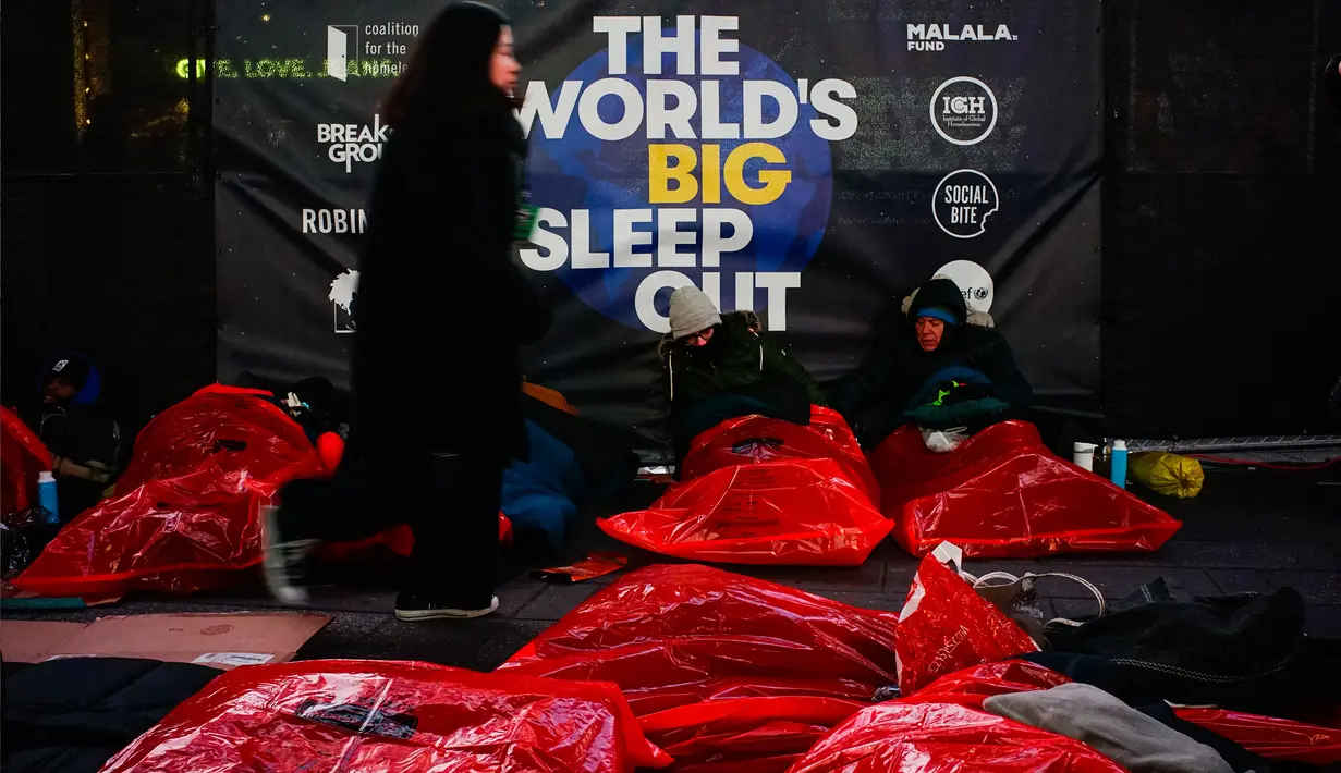 Orang-orang bersiap-siap untuk tidur di area terbuka dalam acara World's Big Sleep Out di Times Square, New York, 7 Desember 2019. Aksi yang dilakukan di beberapa kota besar dunia ini sebagai bagian dari upaya penggalangan dana untuk membantu para tunawisma di banyak negara. (Photo by AFP)