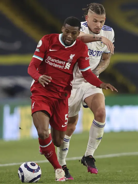 Pemain Liverpool Georginio Wijnaldum (kiri) menggiring bola meninggalkan pemain Leeds United Kalvin Phillips pada pertandingan Liga Inggris di Stadion Elland Road, Leeds, Inggris, Senin (19/4/2021). Pertandingan berakhir dengan skor 1-1. (Clive Brunskill/Pool via AP)