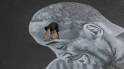 Seorang seniman melukis mural raksasa pada lantai sebuah lapangan basket untuk menghormati mantan bintang NBA Kobe Bryant dan putrinya Gianna di Taguig City, Filipina, Selasa (28/1/2020). Kobe Bryant dan Gianna meninggal dalam kecelakaan helikopter pada 26 Januari 2020. (Xinhua/Rouelle Umali)