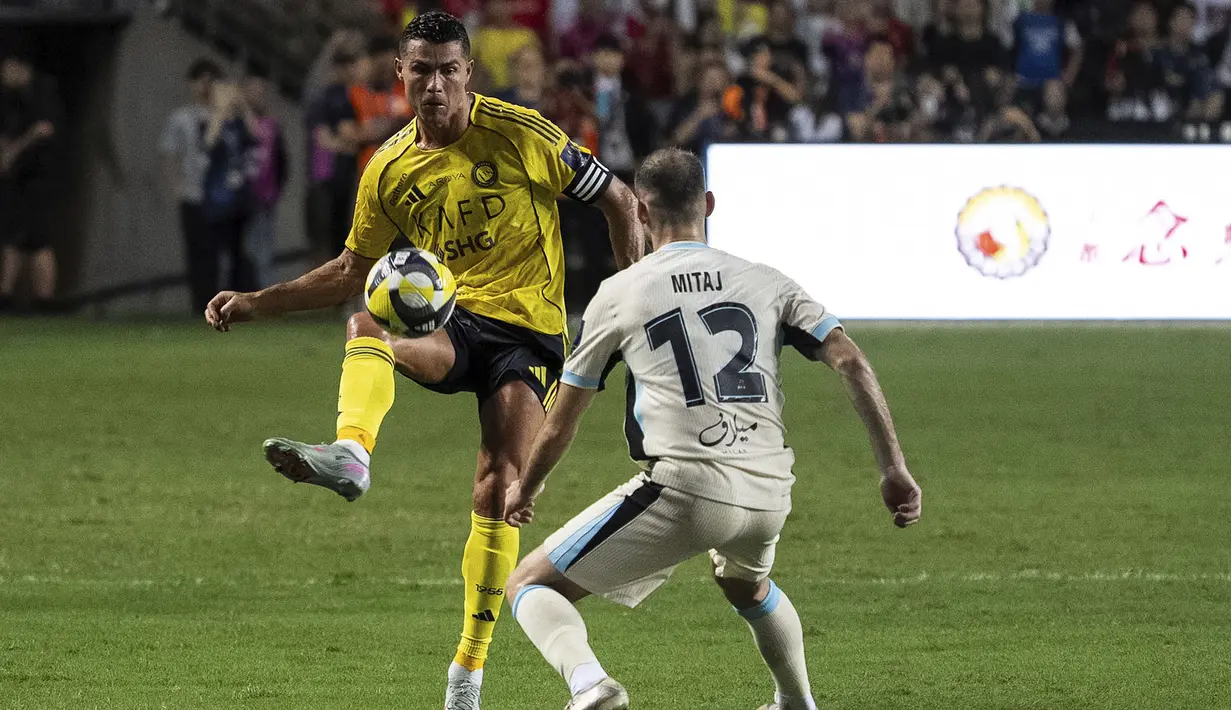 Pemain Al-Nassr, Cristiano Ronaldo (kiri) berebut bola dengan pemain Al-Ittihad, Mario Mitaj dalam laga semfinal Saudi Super Cup 2025 di Hong Kong Stadium, Hong Kong, Selasa (19/08/2025) waktu setempat. (AP Photo/Chan Long Hei)