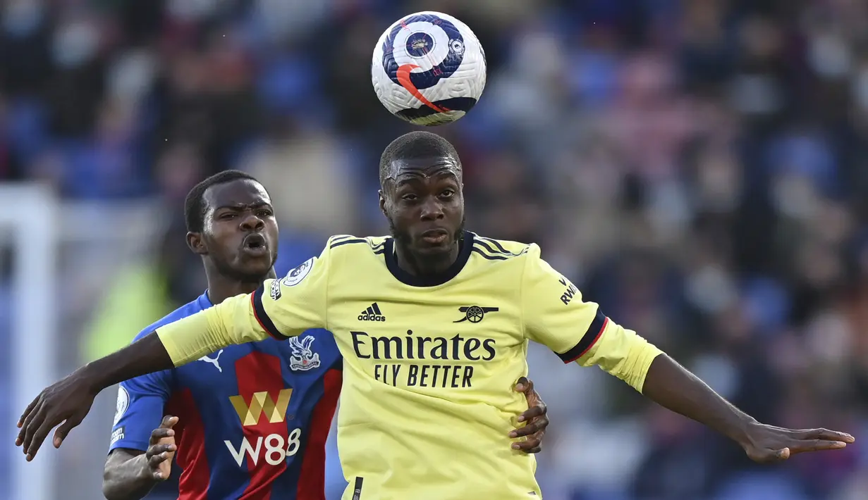 Gelandang Arsenal, Nicolas Pepe (depan) mengontrol bola dibayangi bek Crystal Palace, Tyrick Mitchell dalam laga lanjutan Liga Inggris 2020/2021 pekan ke-37 di Selhurst Park, London, Rabu (19/5/2021). Arsenal menang 3-1 atas Crystal Palace. (AP/Justin Setterfield/Pool)