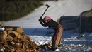 Seorang wanita memotong kayu untuk memasak dan memanaskan di desa Amazigh Timahdite di Atlas Tengah, dekat Azrou, Maroko (4/12/2021). (AP Photo/Mosa'ab Elshamy)