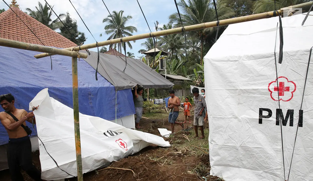 Warga pengungsi Gunung Agung mendirikan tenda di Posko Pengungsi Rendang, Bali, Sabtu (2/12). Bertambahnya jumlah pengungsi membuat mereka harus mendirikan tenda untuk tempat tinggal sementara. (Liputan6.com/Immanuel Antonius)