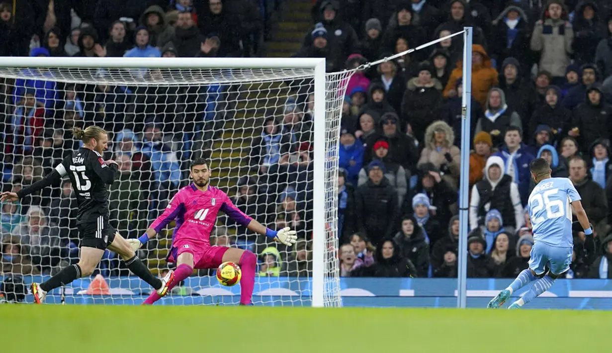 Pemain Manchester City Riyad Mahrez (kanan) mencetak gol ke gawang Fulham pada pertandingan sepak bola putaran keempat Piala FA di Etihad Stadium, Manchester, Inggris, 5 Februari 2022. Manchester City menang 4-1. (AP Photo/Jon Super)