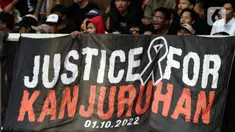 Pendukung timnas Indonesia membentang spanduk bertuliskan “Justice for Kanjuruhan” saat menyaksikan laga kualifikasi Grup A Piala AFF 2022 antara Indonesia melawan Kamboja di di Stadion Utama Gelora Bung Karno, Jakarta, Jumat (23/12/2022). Mereka menyuarakan pengusutan tuntas kasus atas Tragedi Kanjuruhan yang terjadi pada awal Oktober 2022 lalu. (Liputan6.com/Helmi Fithriansyah)