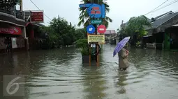 Warga melintasi banjir di perumahan Pondok Hijau Permai, Bekasi, Senin (20/2). Ketinggian air yang merendam perumahan Pondok Hijau Permai mencapai 30-70 cm. (Liputan6.com/Gempur M. Surya)
