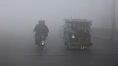Becak dan pengendara sepeda motor melaju di jalan saat kabut tebal mengurangi jarak pandang di Lahore, Pakistan, Selasa (30/11/2021). Lahore secara konsisten menempati peringkat sebagai salah satu kota terburuk di dunia untuk polusi udara. (AP Photo/K.M. Chaudary)