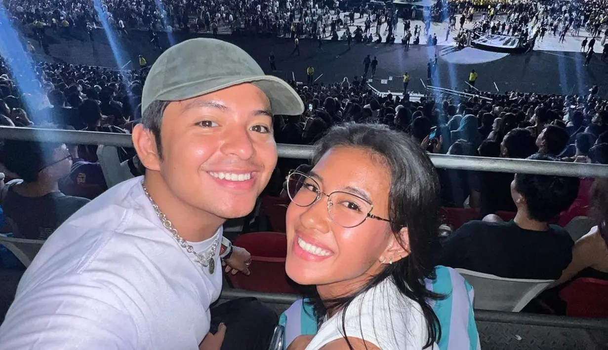 Salah satu konser yang dinantikan masyarakat Indonesia, ini adalah potret Angga Yunanda dan Shenina Cinnamon saat nonton konser Coldplay pada November 2023 lalu. Tampil selaras dengan busana warna putih, Angga dan Shenina bagikan foto manis saat di tribun. Meski hanya memoles wajahnya dengan makeup natural, namun Shenina Cinnamon dipuji cantik. (Liputan6.com/IG/@angga)