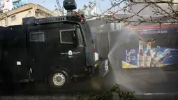 Kendaraan Water Canon kepolisian menyempotkan desinfektan untuk mensterilkan jalan-jalan di Teheran, 1 Maret 2020. Kasus virus corona di Iran mengalami lonjakan tajam dalam beberapa hari dan tercatat memiliki korban meninggal tertinggi setelah China, yang menjadi pusat wabah. (AP Photo/Vahid Salemi)