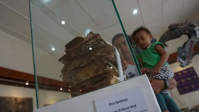 Seniman Oco Santoso merespons bencana ekologis lewat karya tumpukan buku yang terkena banjir.