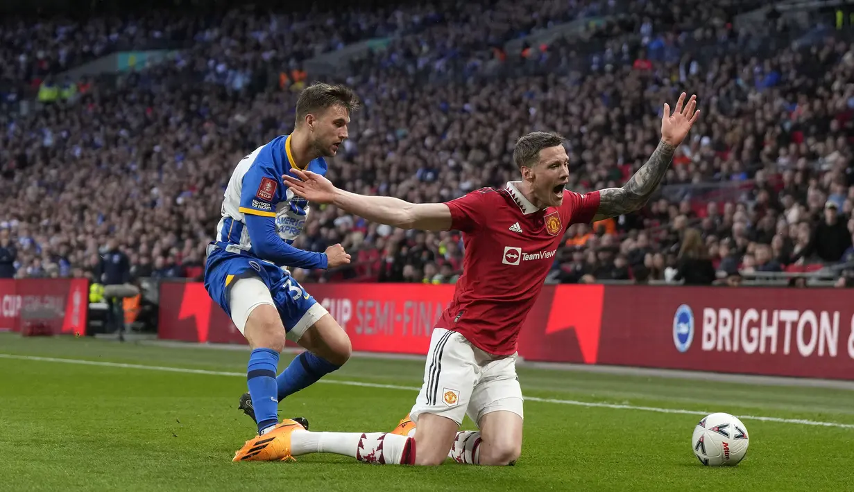 Pemain Manchester United, Wout Weghorst (kanan) berebut bola dengan pemain Brighton, Joel Veltman pada laga semifinal Piala FA 2022/2023 di Stadion Wembley, London, Minggu (23/04/2023). Laga dimenangkan oleh MU dengan skor 7-6 melalui babak adu penalti. (AP Photo/Alastair Grant)