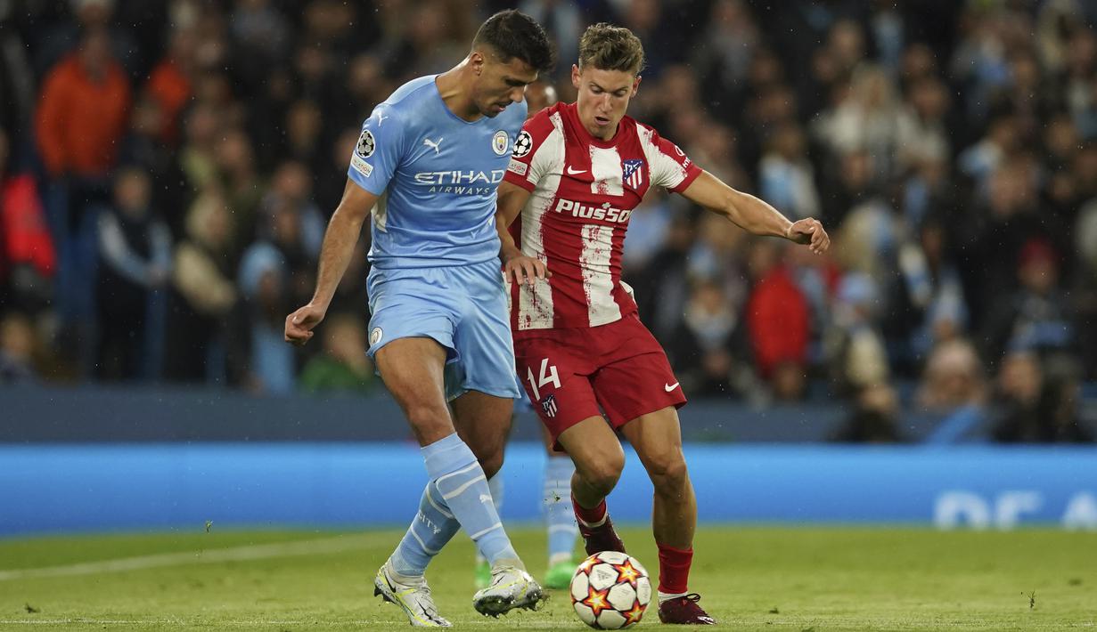Gelandang Atletico Madrid, Marcos Llorente berebut bola dengan bek Manchester City, Rodrigo pada pertandingan leg pertama perempat final Liga Champions di Stadion Etihad, di Manchester, Rabu (6/4/2022). City menang tipis atas Atletico Madrid 1-0.  (AP Photo/Dave Thompson)