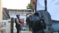 pascabaku tembak polisi dan kelompok MIT di Poso, Personel Polda Sulteng berjaga di pintu masuk RS Bhayangkara Palu pada 16 Mei, 2020. Pemeriksaan ketat dilakukan termasuk terhadap jurnalis yang ingin masuk.