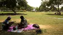 Warga duduk di bawah pohon selama musim panas di New Delhi, India (10/6/2019). Kondisi gelombang panas yang parah menyapu bagian utara dan barat India dengan suhu maksimum melonjak hingga 48 derajat Celcius ( 118 F) di beberapa bagian Rajasthan. (AP Photo/Manish Swarup)