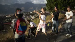 Para pemuda menerbangkan layang-layang dalam acara peringatan 400 tahun permukiman kumuh Petare di Caracas, Venezuela (17/2/2021). Kemiskinan tetap menjadi kendala utama perkembangan kota ini. (AP Photo/Ariana Cubillos)