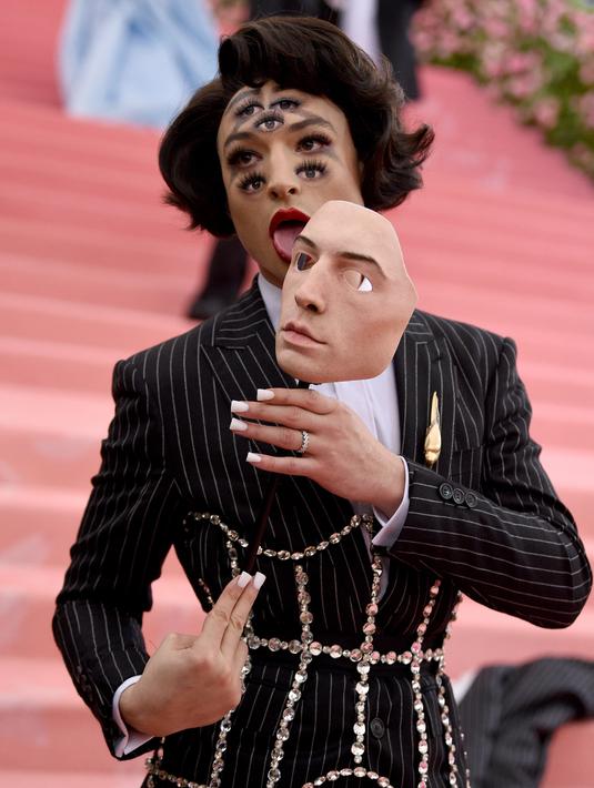 Ezra Miller merias wajahnya dengan banyak mata saat menghadiri Met Gala 2019 bertema Camp: Notes on Fashion di The Metropolitan Museum of Art, New York, Amerika Serikat, Senin (6/5/2019). (Photo by Evan Agostini/Invision/AP)